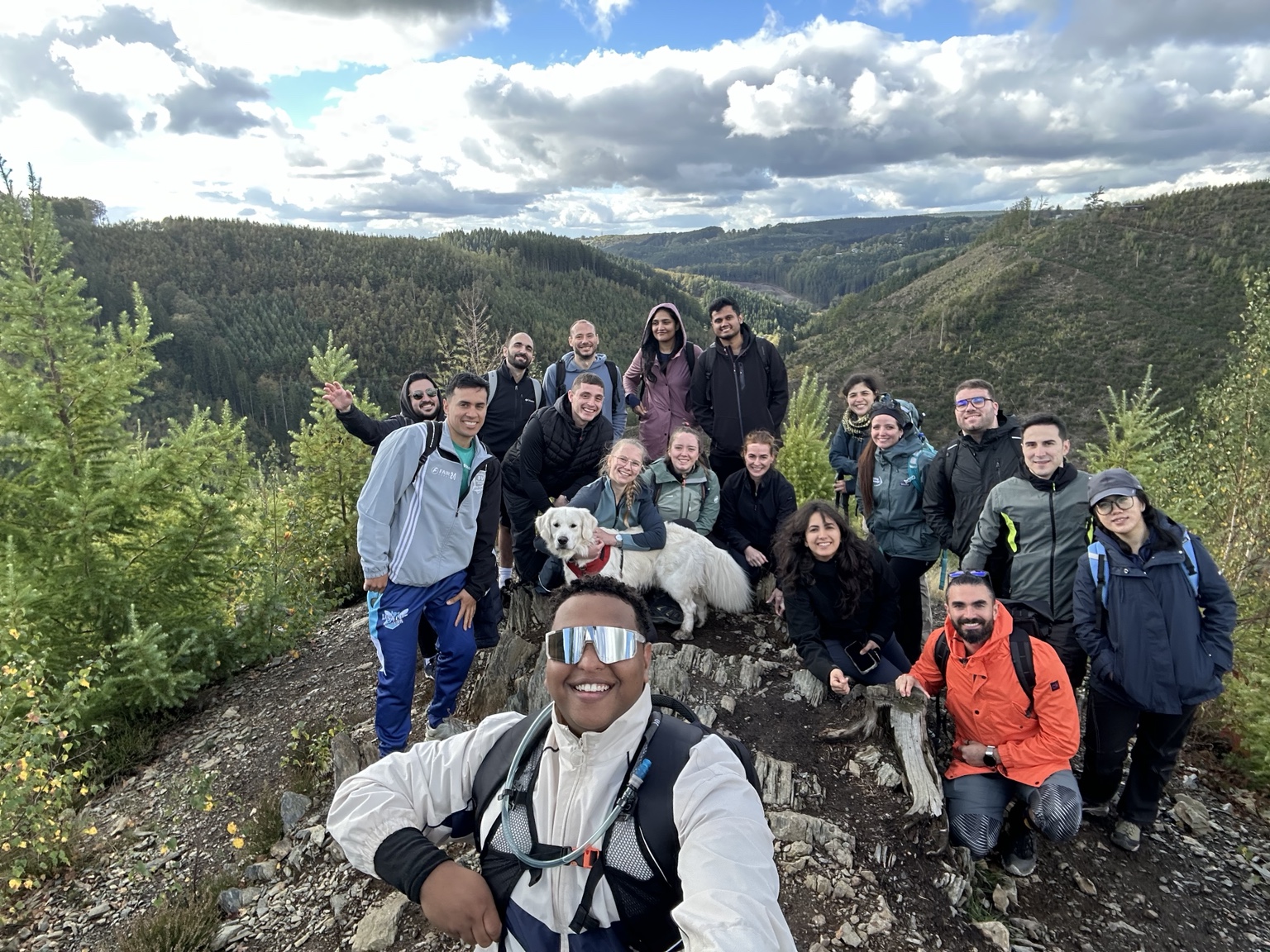 Walid on a hiking trip with a group overlooking a forested valley